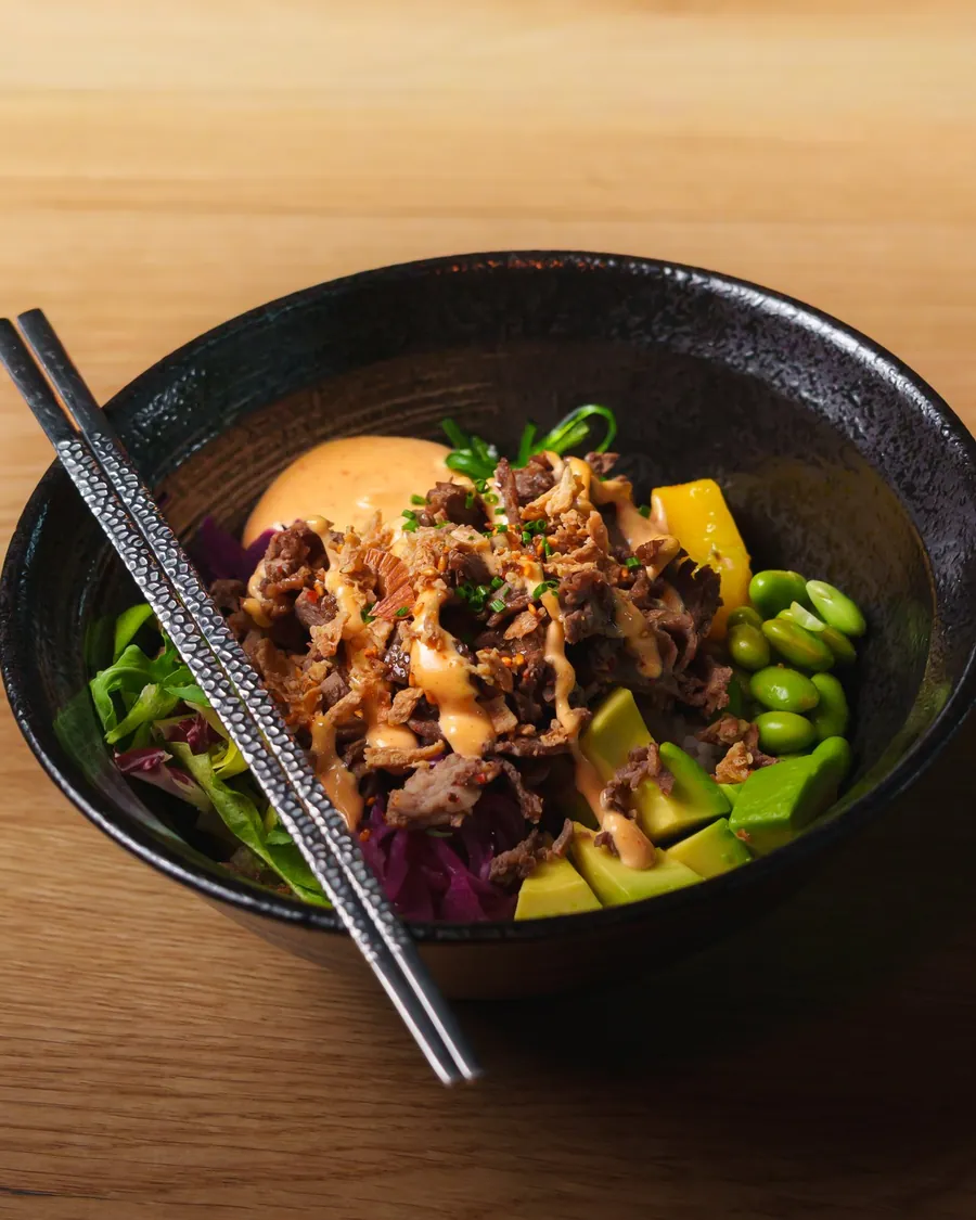 A Bōru rice bowl with chopsticks on a wooden table